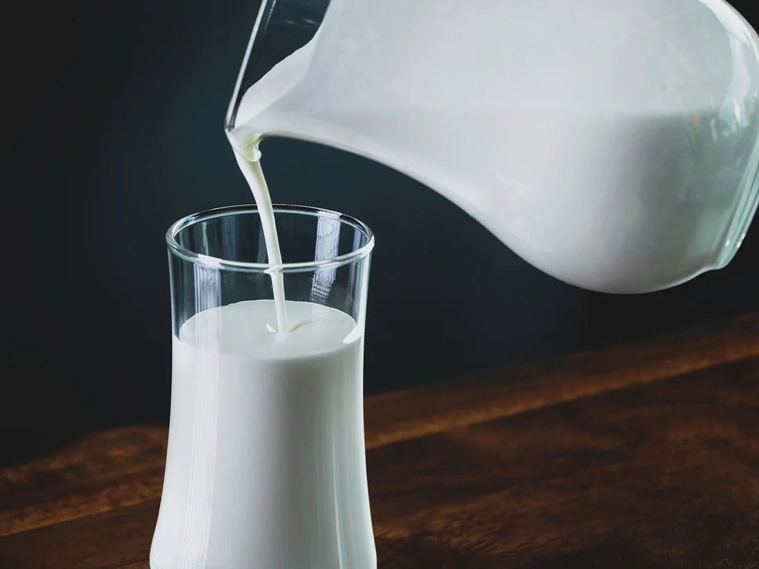 Milk being poured from a glass jug